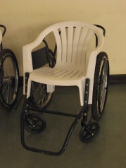 A wheelchair assembled from spare parts and cheap porch furniture